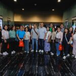 Post-screening group photo of attendees outside the theater