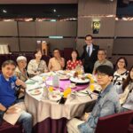 Guests seated at a formal dinner table with festive decor