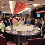 Guests seated and smiling during the dinner program
