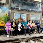 Group seated along railway café during Vietnam city visit